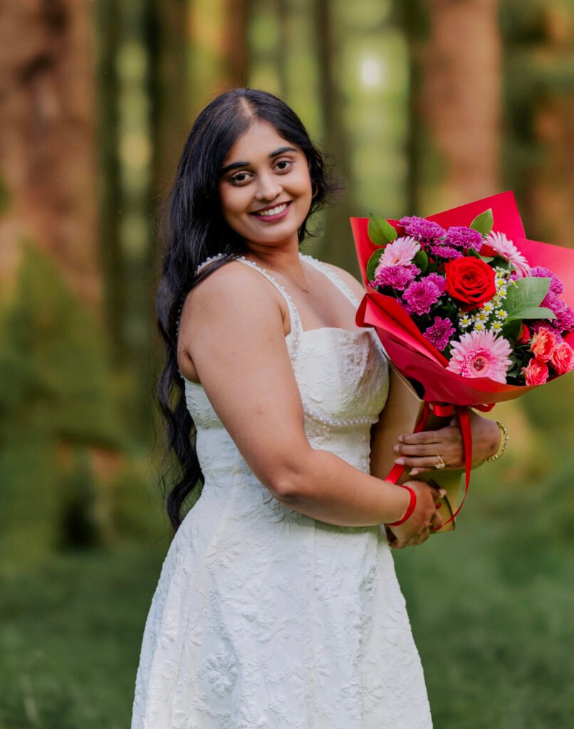 Woman in a white dress holding red roses – outdoor portrait session in Cork