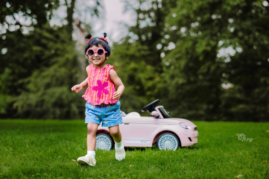 Toddler in sunglasses beside a toy car – children's photoshoot in Cork