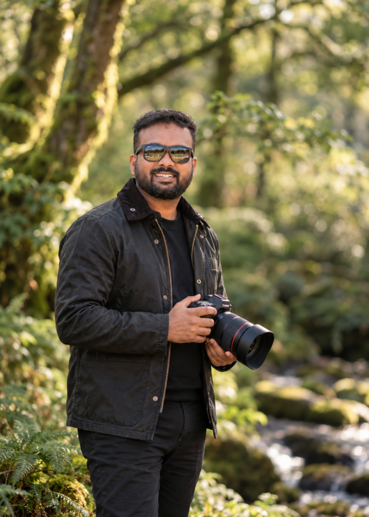 Rijo of JoFrames, photographer and videographer, holding a camera in a Cork woodland